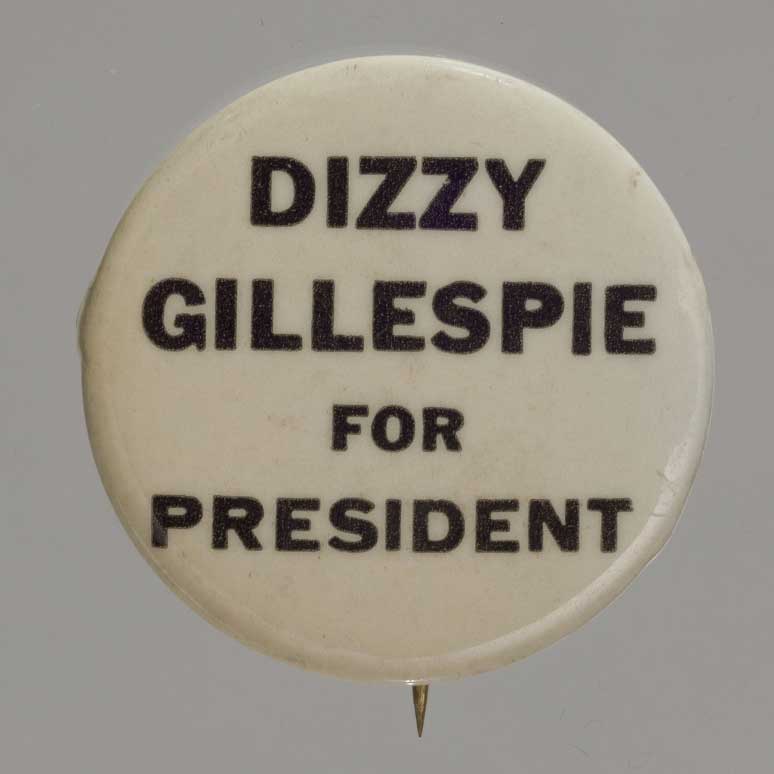 A small political pin-back button with black on white lettering that reads: [Dizzy Gillespie for President] Collection of the Smithsonian National Museum of African American History and Culture, Gift of Jeff Gold and Jody Uttal Gold